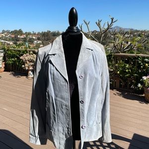 100 % Leather feels like suede. Pretty blue and lined. Needs to be dry cleaned.